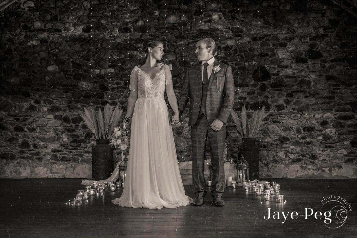 a bride and groom in the loveable old barn at low hall the lakes in the lake district
