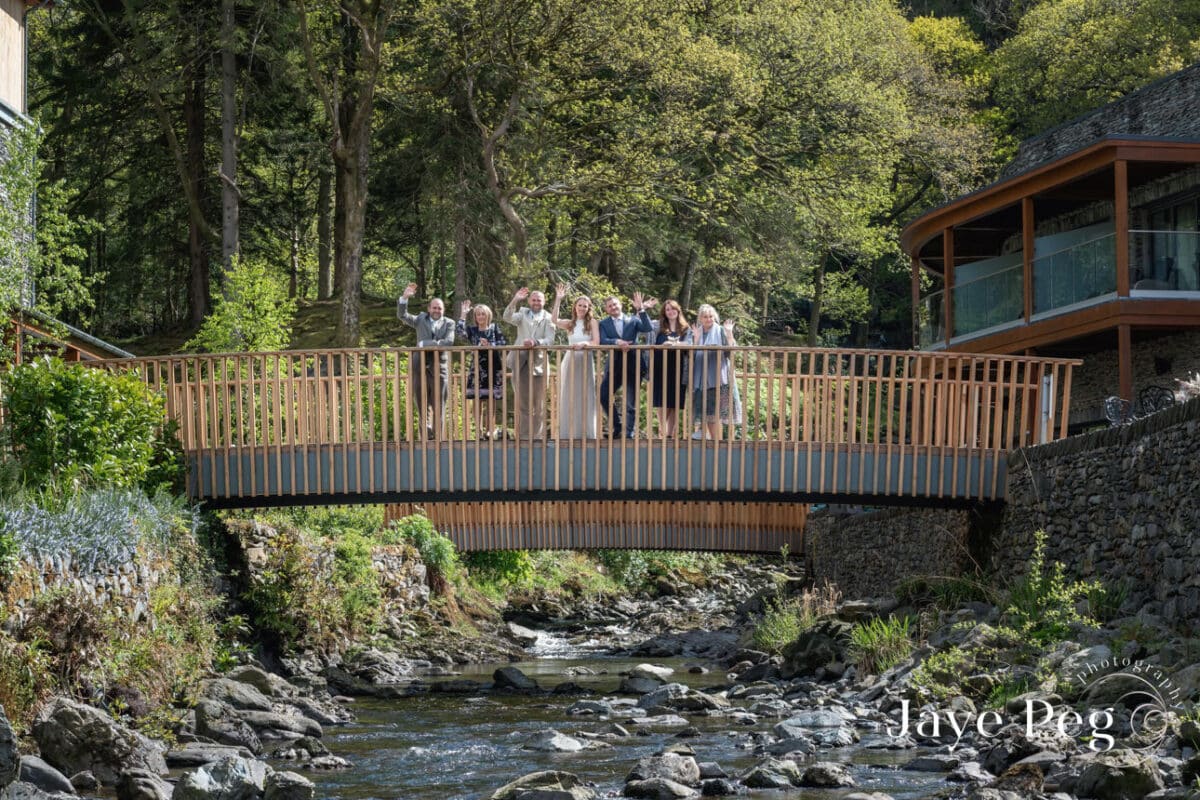 Group on bridge in forested area smiling.