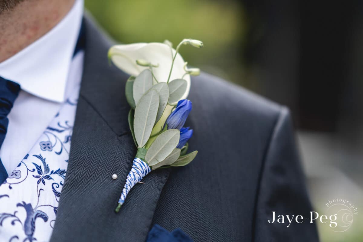 Groom's boutonniere with blue details on suit jacket