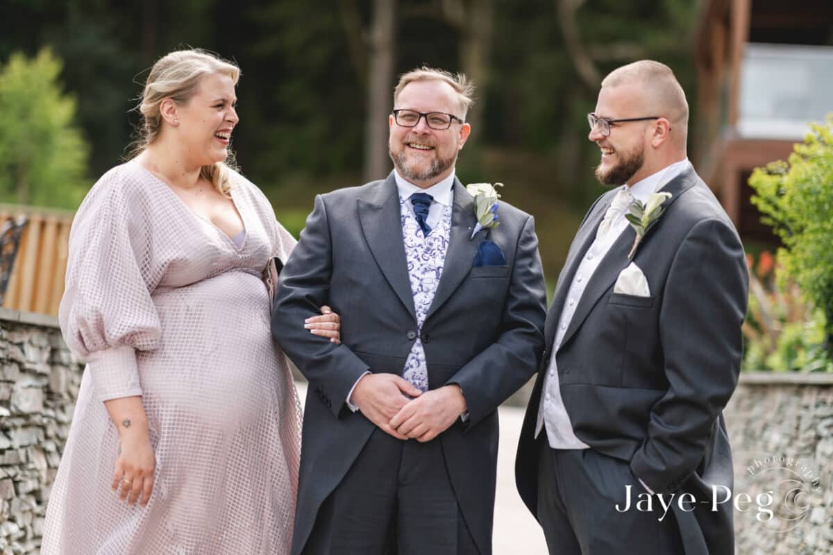 Wedding guests laughing outdoors.