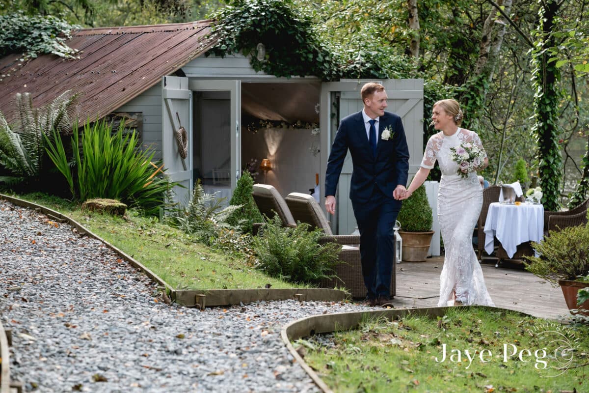 a bride and groom walk from the boat house at gilpin lake house