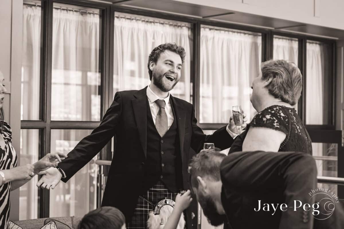 Man in suit laughing at celebration with champagne