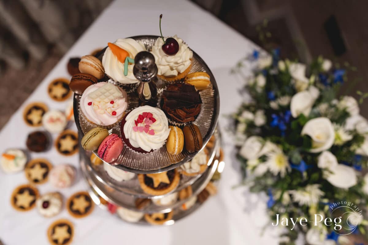 Assorted desserts on elegant tiered stand at event.