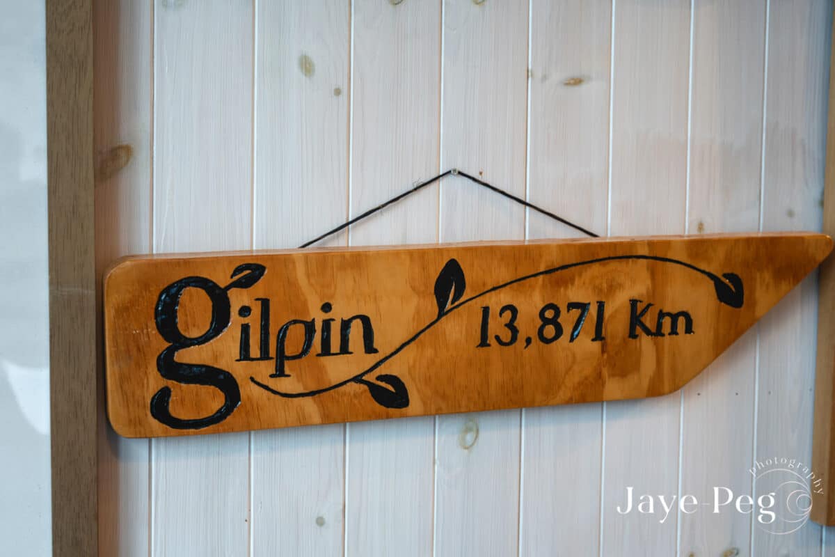 a sign for gilpin hanging on a wood panelled wall in the boat house at gilpin lake house