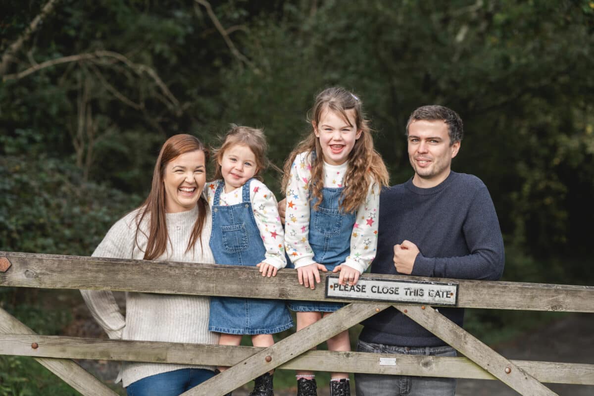 a family photographed over a woodland gate
