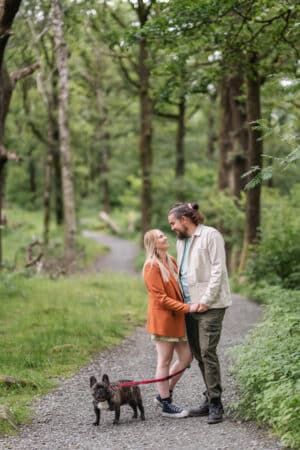 a couple with their dog on a woodland path